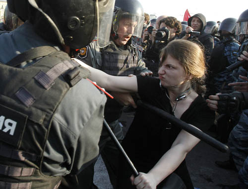 A participant is restrained by Russian riot police during the "march of the million" opposition protest in central Moscow