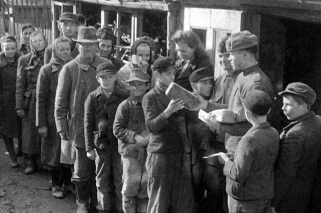 Советские воины раздают хлеб жителям города Бреслау в годы Великой Отечественной войны.
